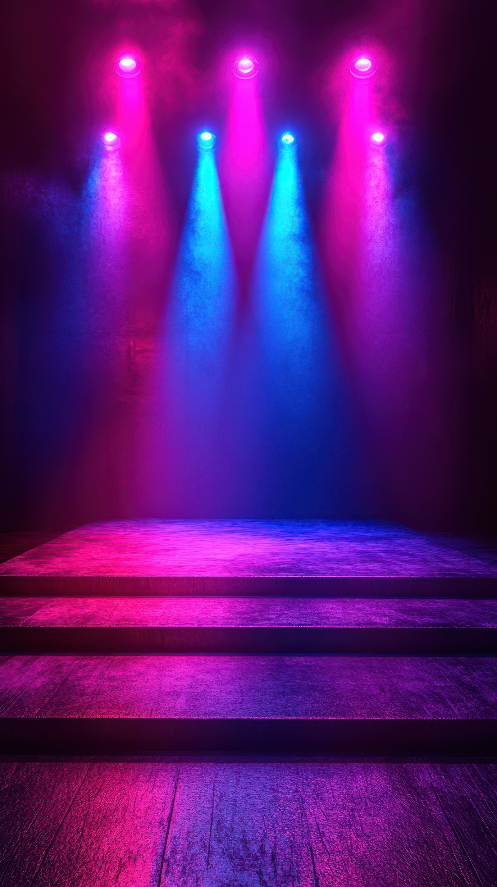 Colorful stage lighting creates an energetic atmosphere for a performance in a dark venue with wooden flooring